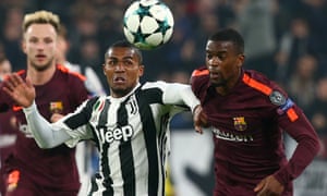 Juventus’ Douglas Costa races Barcelona’s Nelson Semedo for the ball.