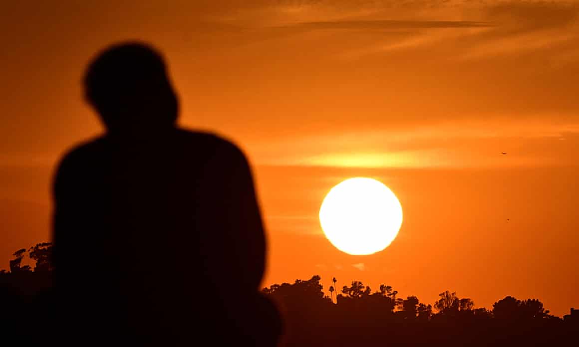 The silhouette of a man watching a sun set in Los Angeles