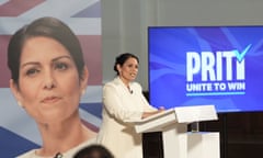 Priti Patel standing at a lectern