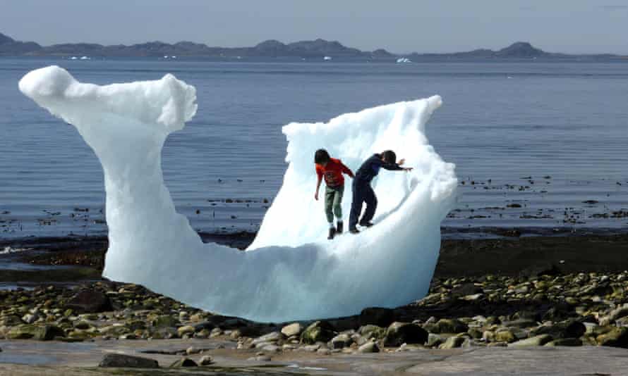 Children play amid icebergs on the beach in Nuuk, Greenland