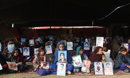 Women and children hold posters of their disappeared loved ones