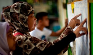 Muslim women look for their names at a voting precinct in Maguindanao, on the southern island of Mindanao. A decades-long push to halt the violence that has claimed some 150,000 lives in the southern Philippines culminates with a vote on giving the nation's Muslim minority greater control over the region.
