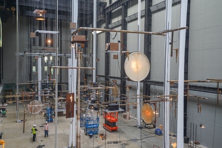 Workers build musical equipment into an installation in the vast Turbine Hall