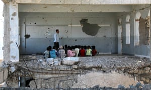 Yemeni children attend class in a bomb-damaged school in Taez on the first day of the new academic year on 3 September.