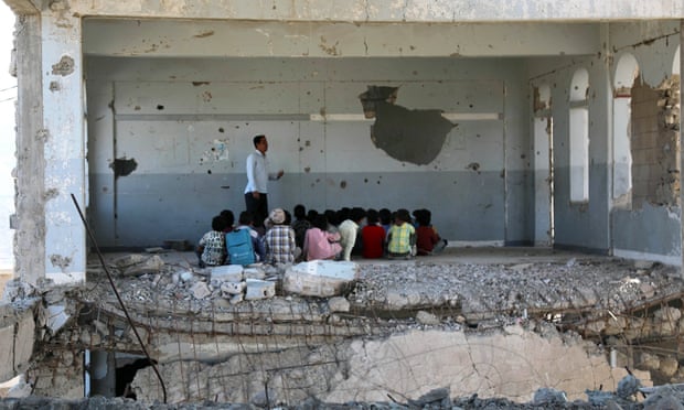 Yemeni children attend class in a bomb-damaged school in Taez on the first day of the new academic year on 3 September.