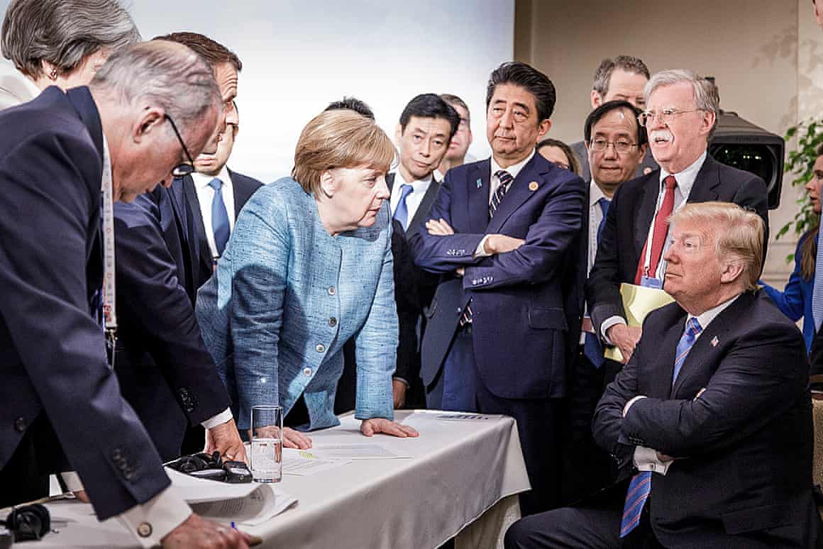 Merkel stares down Trump, flanked by Larry Kudlow, the director of the US National Economic Council, Theresa May, the UK prime minister, Emmanuel Macron, the French president, Yasutoshi Nishimura, the Japanese deputy chief cabinet secretary, Shinzo Abe, the Japan prime minister, Kazuyuki Yamazaki, the Japanese senior deputy minister for foreign affairs, and John Bolton, the US national security adviser.
