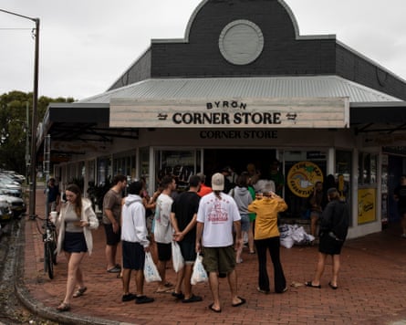 People line up outside of a corner store