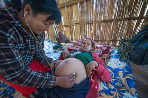 A midwife examines a heavily pregnant woman in Myanmar’s Chin State