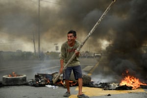Limonal, EcuadorA man protests in front of a burning roadblock on a road to Guayaquil, during demonstrations against the government due to price increases