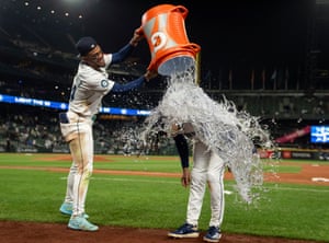 The Seattle Mariners centre fielder Julio Rodriguez douses his teammate JP Crawford with water from a drinks bucket