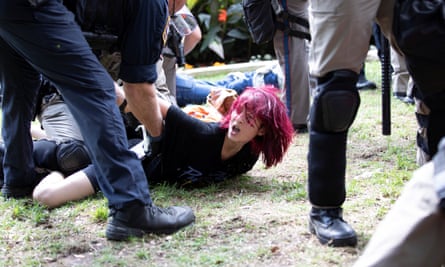 A protester held on the ground by police