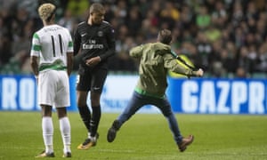 A Celtic fan runs on the pitch and confronts Paris Saint-Germain striker Kylian Mbappé during Celtic’s 5-0 defeat