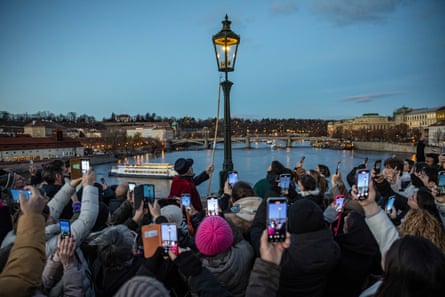 A lamplighter at work on Charles Bridge in Prague, Czech Republic, December 2024.