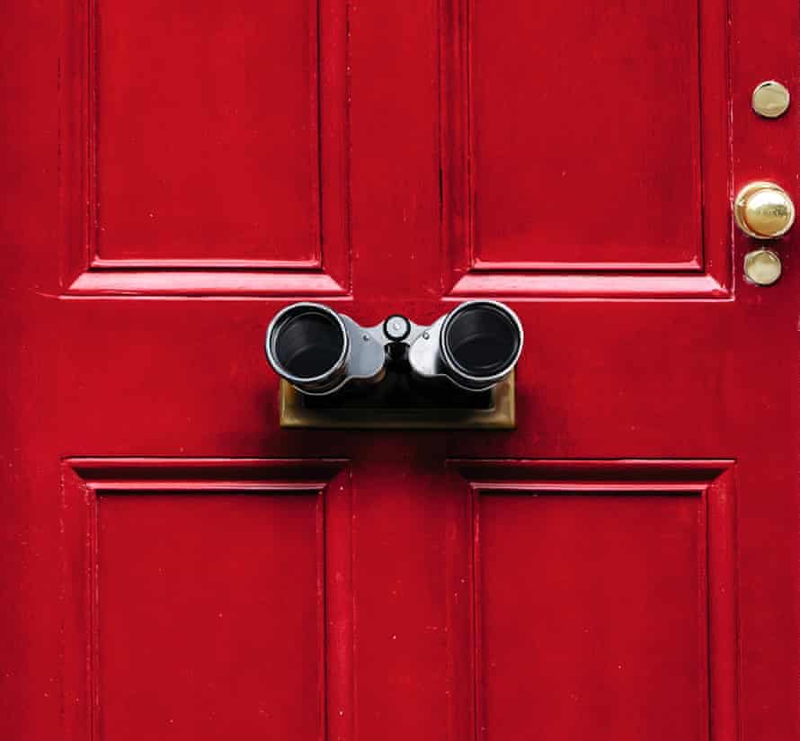 A red front door with binoculars sticking out of the letterbox