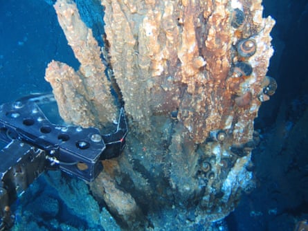 A robotic arm breaks off a chunk of mineral-rich rock for sampling deep underwater near Papua New Guinea.