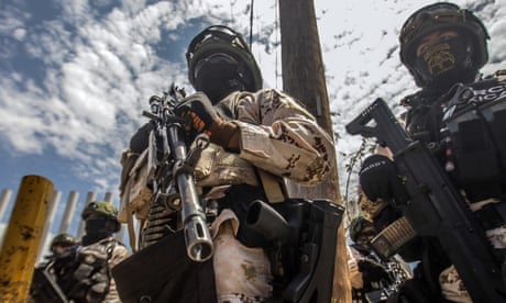 Heavily armed national guard soldiers looming ominously against the sky