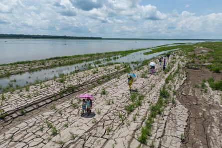 people walk along hard cracked ground