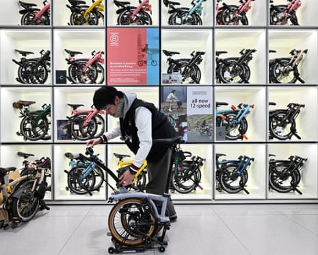 A shop attendant unfolds a Brompton folding bicycle at a shop in Beijing