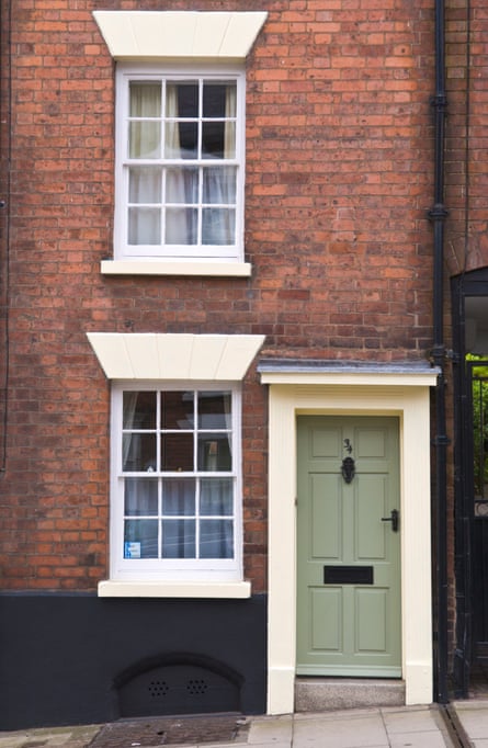 Petite maison de ville avec porte d'entrée verte et cadre de couleur crème et fenêtres à guillotine blanches à Ludlow, Shropshire