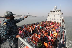 Chittagong, BangladeshRohingya refugees sit on a Bangladesh navy ship as they are relocated to the controversial flood-prone island of Bhashan Char in the Bay of Bengal