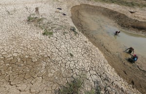 Fishermen search for a catch in the mud of a dried-up pond in Cambodia’s drought-hit Kandal province