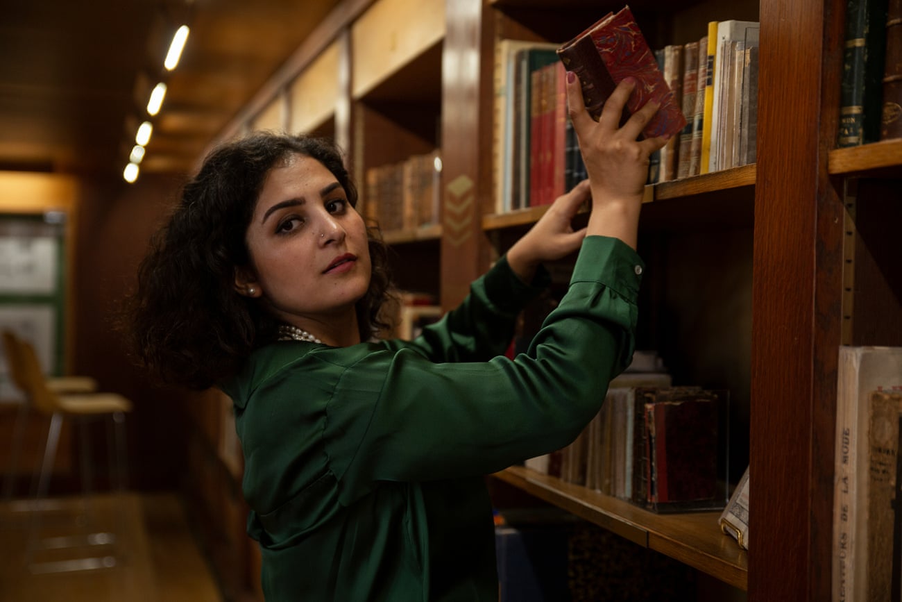 Mursal Sayas, an Afghan writer, puts a book on a shelf in a library