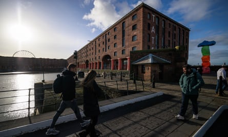 People walk outside the closed venue on the Albert Dock.