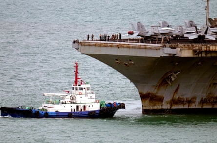 A tug boat greets the USS Abraham Lincoln as it arrives at the port in Laem Chabang, Chonburi, Thailand.