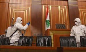 Sanitary workers disinfect the desks and chairs of the Lebanese Parliament in central Beirut amid the spread of coronavirus in the country.