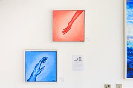 A blue painting with a hand reaching towards a red painting with a hand reaching back. The pieces are by Fope A. 