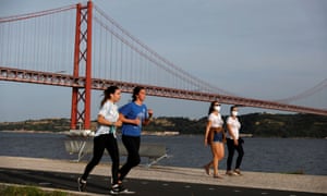 People walk past 25th April Bridge along the Tagus river, in Lisbon, Portugal, May 3, 2020. REUTERS/Rafael Marchante