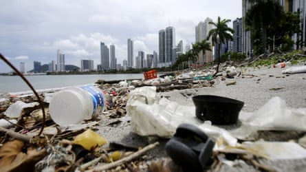 Plastic bottles washed up on a beach with a view toward Panama City.