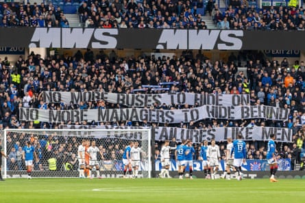 Rangers fans hold a critical banner during the game against Dundee United