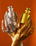 silver and gold hands holding silver and gold perfume bottles