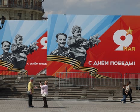 Passersby walk against the backdrop of billboards commemorating Victory Day in Moscow, Russia.