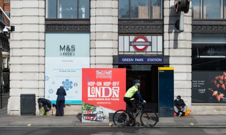 man rides a bicycle past homeless people along Piccadilly in central London as the UK’s nationwide lockdown continued on 7 April 2020.