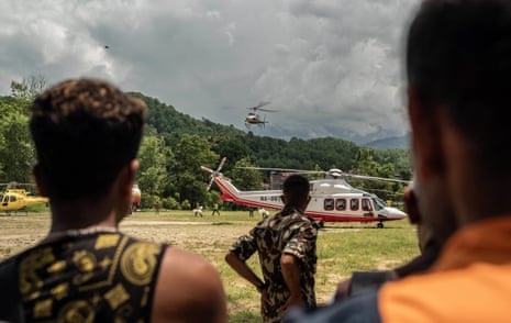 A helicopter landing near several others