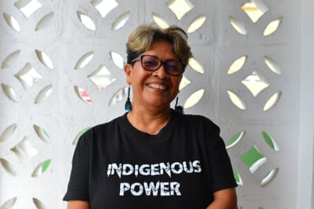 A smiling woman in a t-shirt that says ‘Indigenous power’