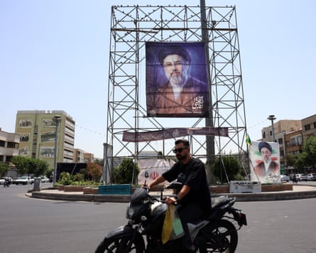 A man drives next to a billboard of Iranian supreme leader Ayatollah Mojtaba Khamenei in a street in Tehran