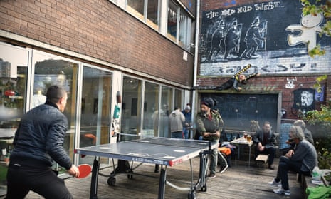 Men play table tennis in a Bristol pub garden that features The Mild Mild West, a Banksy mural that depicts a teddy bear throwing a Molotov cocktail at riot police.