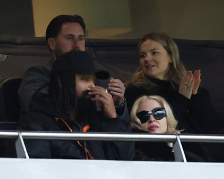 Madonna and her partner, Akeem Morris, watch from the stands.