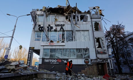 A worker removes debris in front of an office building damaged by shelling in Donetsk, in Russian-controlled Ukraine.