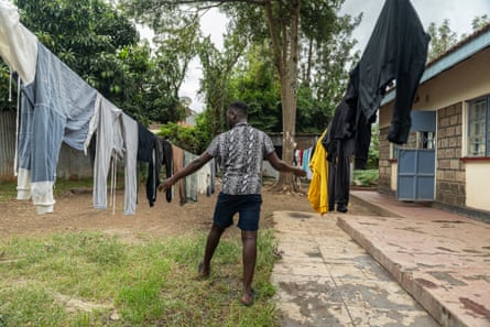A man stands alongside two washing clothes lines
