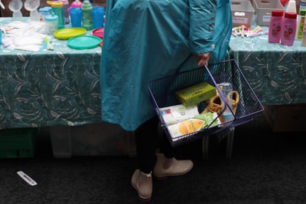 Bir kadın bebek eşyalarının bulunduğu bir alışveriş sepeti taşıyor