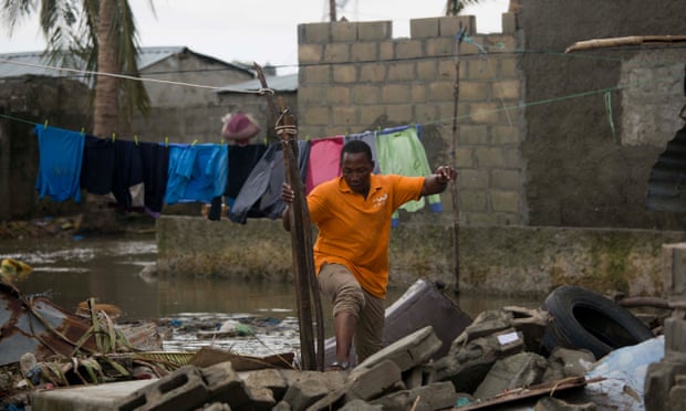 A man balances on rubble surrounded by flood waters in Beira, Mozambique