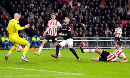 Luuk de Jong perst de bal tussen de benen van de doelman om PSV op de rem te zetten.