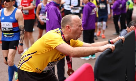 Matt Hancock grimacing in yellow top after finishing the London marathon