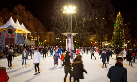 Christmas Market in Oslo. People in the Spikersuppa ice skating rink in middle of town where the Christmas market is also set