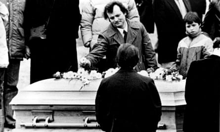 Actor Bill Murray places a flower on Belushi’s coffin at his funeral in 1982.