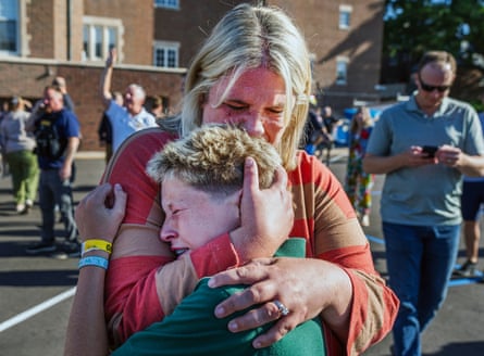 A mother embraces her crying son